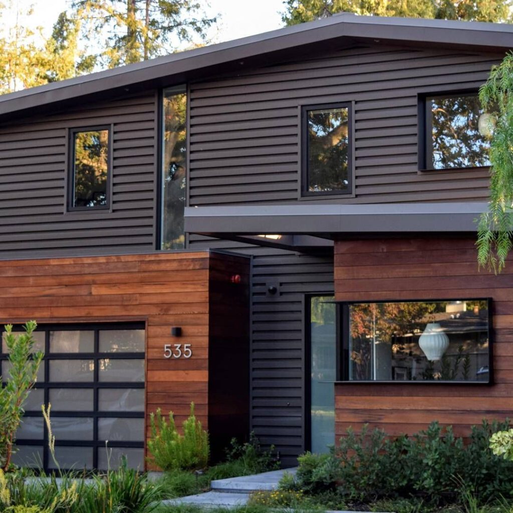 Black house with wooden garage door