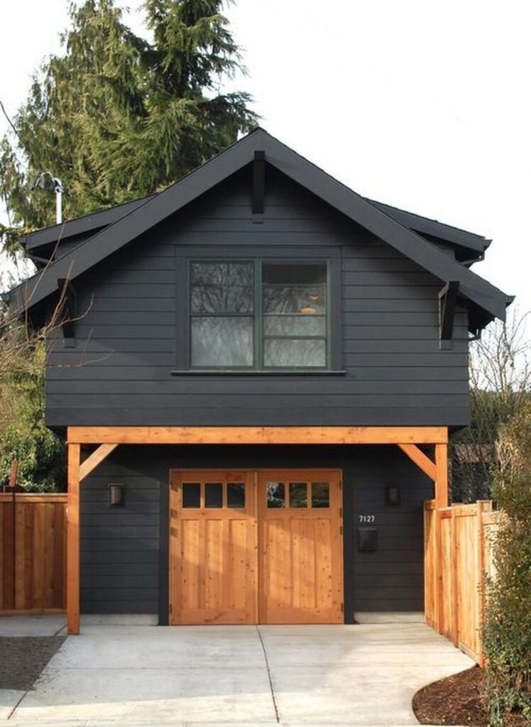 Black house with wooden garage door